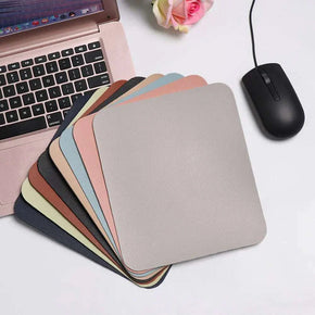 Variety of waterproof mouse pads with a laptop and mouse on a desk.